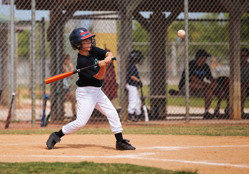 Baseball player hits the ball.