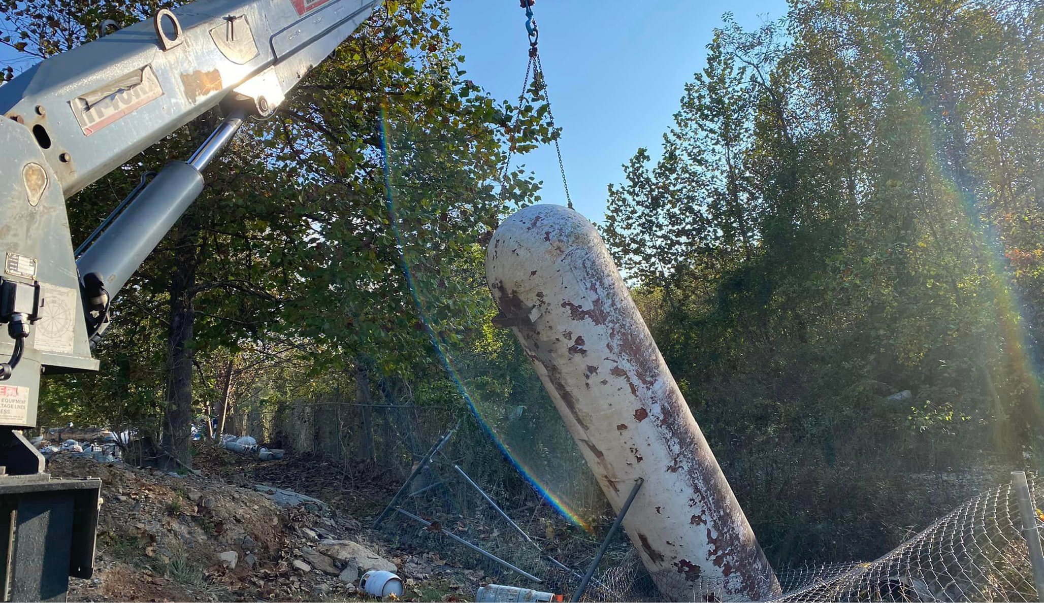 Crane pulls large propane tank out of post-flood wreckage
