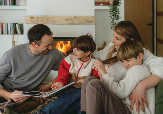 A family gathered together in front of a propane fireplace.