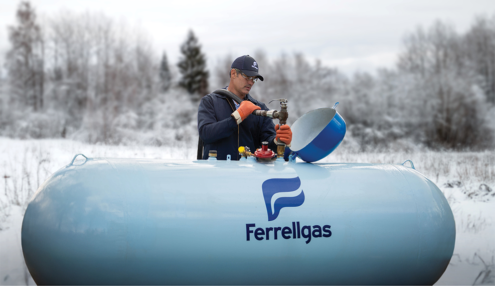 Ferrellgas Delivery Driver filling a residential propane tank in winter.