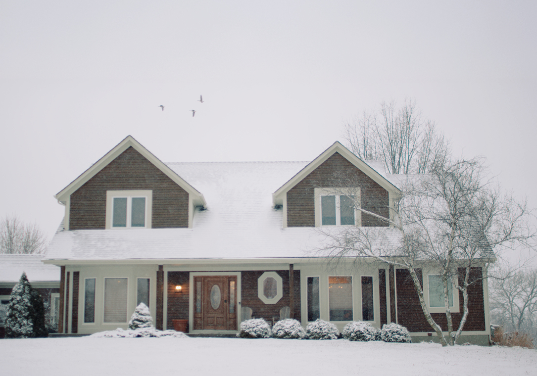 The front of a snow-covered home in winter.