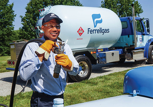 A Ferrellgas Delivery Driver, wearing safety gloves and glasses, stands near a delivery truck.