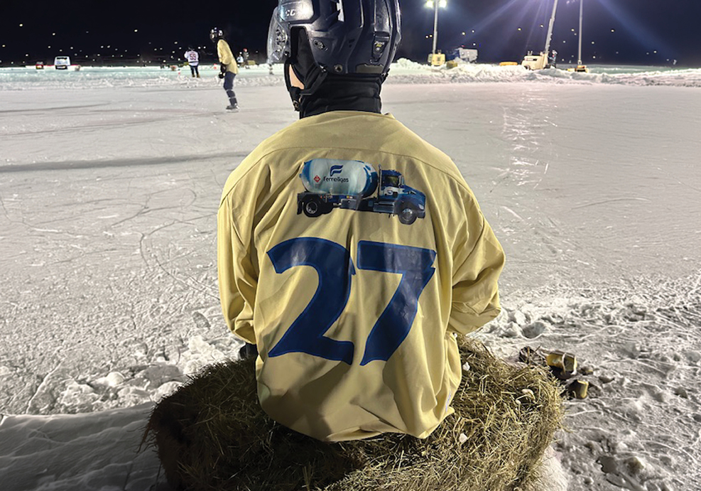 Hockey player watches his teammates play.
