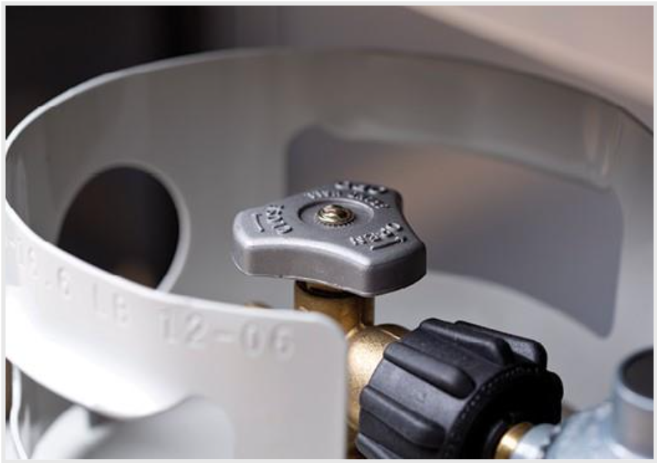 The top of a grill-sized propane tank, showing the manufacturing date and requalification markings.