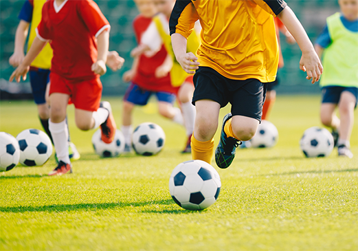 Kids run down the field during a youth soccer game.